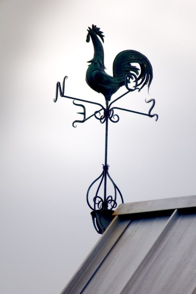 A weather vane on the roof of a house