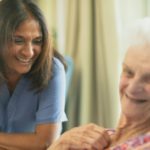 Nurse smiling with elderly patient in room