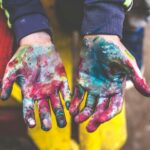 person showing both palms with paints